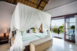 een slaapkamer met een hemelbed bij The Point Resort Lembongan in Nusa Lembongan