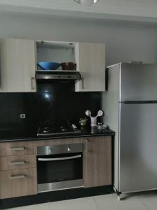 a kitchen with a stove and a refrigerator at Les terrasses 2 in Mansouria