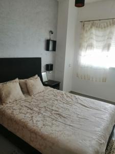 a bedroom with a large bed and a window at Les terrasses 2 in Mansouria