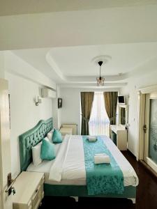 Un dormitorio con una cama grande con almohadas azules. en LA MAİSON FAMILY Hotel, en Estambul