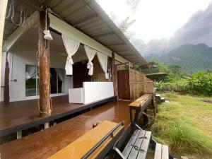 Una casa con una mesa y bancos bajo la lluvia en Pond Pond Chiangdao, en Ban Tham