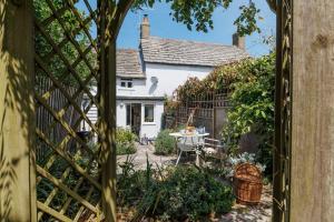 a view of a garden with a table and a house at Angel Cottage in Swanage