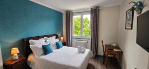 a bedroom with a bed with blue walls and a window at Source de la Vallée in Sadroc