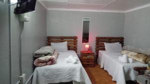 a bedroom with two beds and a candle on a table at The Croc Backpackers in Springs