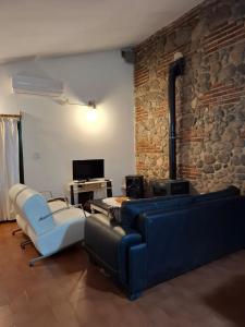 ラ・グラニャにあるLa Granjaの青いソファと石壁のリビングルーム +19枚の写真