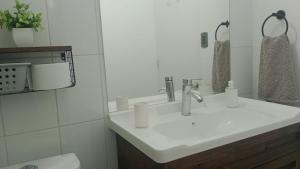 a white bathroom with a sink and a toilet at APARTAMENTO In HOUSE ALAMEDA in Santiago +2 photos