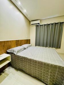 a bedroom with a large bed in front of a window at INCRIVEL FLAT 3 MINUTOS do CENTRO COM CHURRASQUEIRA E AR CONDICIONADO in Formosa