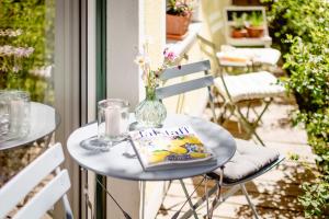 a table with a book and a vase on it at s`Hauserl 311 - Your Austrian Home in Altaussee