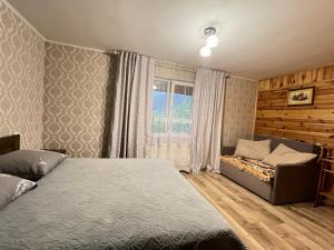 a bedroom with a bed and a couch and a window at Захід сонця in Slavske