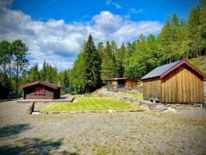 a couple of buildings in a field with trees at Raundalen in Løyte +16 photos
