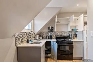 Una pequeña cocina con fregadero y estufa. en King Bed | WiFi Desk | Air Hockey | Car Bed, en East Orange