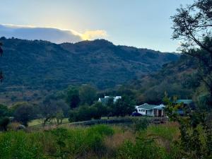 a house on a hill with mountains in the background at La Ronel Guest Farm in Roossenekal +2 photos