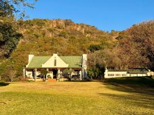 a house with a green roof on a grass field at La Ronel Guest Farm in Roossenekal