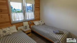 a bedroom with two beds and a window at Dom u Stasi in Niemirów