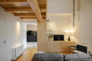 a living room with a couch and a tv at Gateway House Studio Apartments in Guimarães
