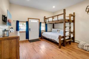 a bedroom with two bunk beds and a desk at 5 min Ski| 1 min Nightlife| Hot Tub| Arcade| Fires in Killington Village