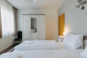 una camera da letto con un letto bianco e una sedia di Apartment Zentral a Bad Tatzmannsdorf
