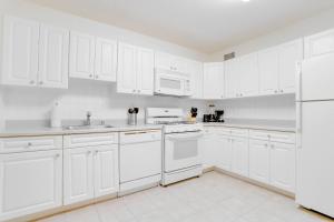 a white kitchen with white appliances and white cabinets at Spacius Apt W Excellent Amenities in Arlington