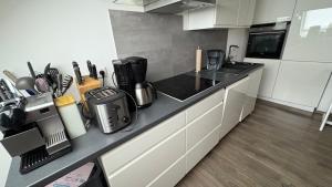 a kitchen with white cabinets and a black counter top at Wunderschöne Wohnung in Erftstadt-Liblar 15 Minuten bis zum Phantasialand! in Erftstadt