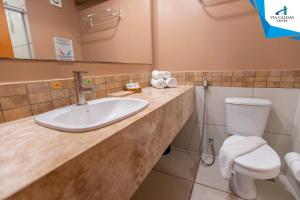 une salle de bain avec un lavabo et des toilettes dans l'établissement Le Jardin - Via Caldas, à Caldas Novas 21 autres photos