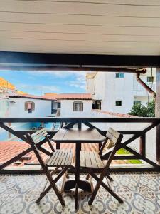 a table and chairs on a balcony with a view at Pousada Recanto das Tartarugas - Nova Direção in Arraial do Cabo