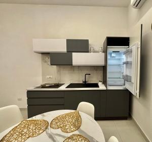 a kitchen with a sink and a table with chairs at Lindas Room in Pozzuoli