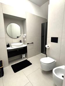 a bathroom with a sink and a toilet and a mirror at Lindas Room in Pozzuoli