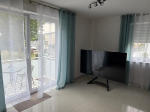 a flat screen tv in a living room with windows at Stilvolles Appartment in Paderborn
