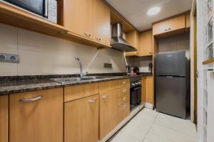 a kitchen with wooden cabinets and a stainless steel refrigerator at Casa en Barcelona in Barcelona