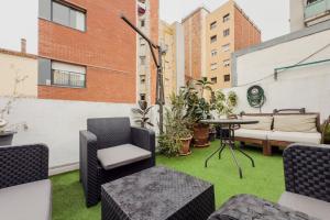 an apartment patio with grass and chairs and a table at Casa en Barcelona in Barcelona