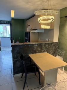 a kitchen with a table and a chandelier at 1605 dos quartos Beach Class Vista Mar in Fortaleza +7 photos