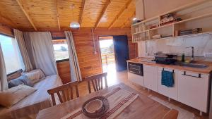 Una cocina y sala de estar de una cabaña de troncos en Entre Sierras y Sueños, en Villa Yacanto