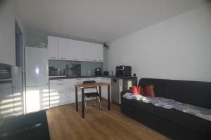 a small kitchen with a table and a couch at la brise marine in Plage dʼArgelès