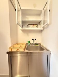 a kitchen counter with a sink and a cabinet at Naxos City Hostel in Naxos Chora