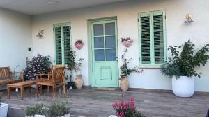 a house with a green door and chairs and potted plants at Matilda's house in Majdal Shams