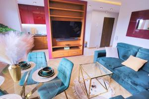 a living room with blue furniture and a tv at Apartament Chopina Premium in Suwałki