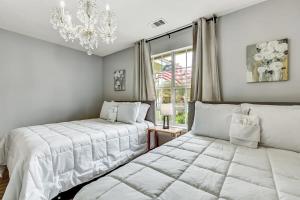 a bedroom with two beds and a chandelier at 15 Mins to Hospital&Downtown! Brandlewood Bungalow in Savannah