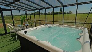 a hot tub in a tent with a view of a field at Le Gros Hêtre in Saint-Mards-de-Blacarville