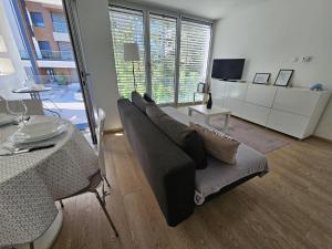 ein Wohnzimmer mit Sofa und Tisch in der Unterkunft Maslacak Lila Apartment in Zlatibor