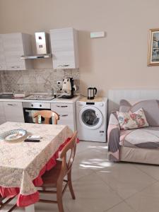 a kitchen with a table and a washing machine at Suit catania1946 in Catania