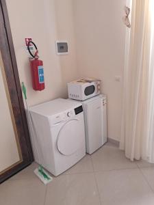 a washing machine with a microwave on top of it at Suit catania1946 in Catania