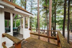 a porch of a house with a table in the woods at Lakeview Cottage with Pontoon Rentals in Traverse City