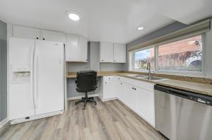 a kitchen with white cabinets and a white refrigerator at His Grace Garden Apartment in Villa Park +3 photos