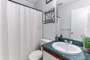 a white bathroom with a sink and a toilet at 20 Mins from the Airport- Sunny Soling Hideaway in Savannah +27 photos