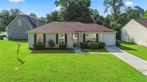 a home with a green yard with a house at 20 Mins from the Airport- Sunny Soling Hideaway in Savannah