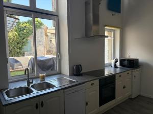 a kitchen with a sink and a window at Atypical house with terrace in Salles-sous-Bois