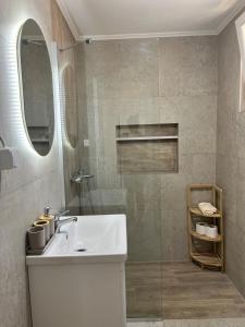 a bathroom with a sink and a glass shower at A&A apartments in Kotor +7 photos