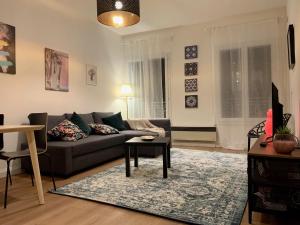 a living room with a couch and a table at Le Quatre superbe T2 Internet WiFi Coeur historique Parking 45 m2 in Béziers