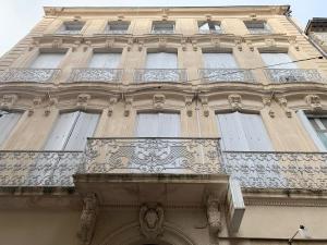 a tall building with windows on the side of it at Le Quatre superbe T2 Internet WiFi Coeur historique Parking 45 m2 in Béziers
