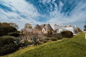 a large house with a stone wall and a yard at i Trulli di Figazzano in Locorotondo